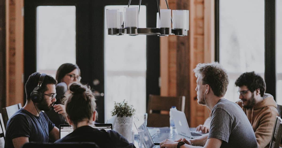 Photo d'une équipe au travail autour d'ordinateurs, utilisée pour illustrer une évaluation de candidats plus structurée.